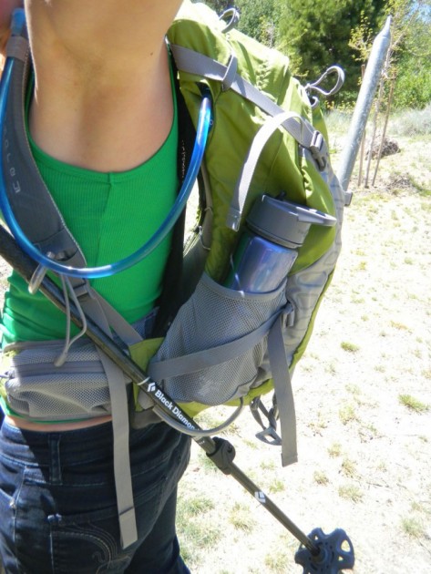 a close up of how the trekking pole attachment works while wearing...