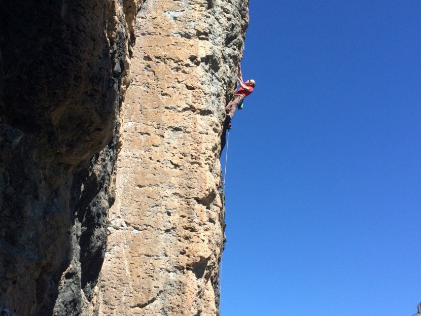 edelrid zack - climbing steep pockets on welded tuff, high above the ground at a...