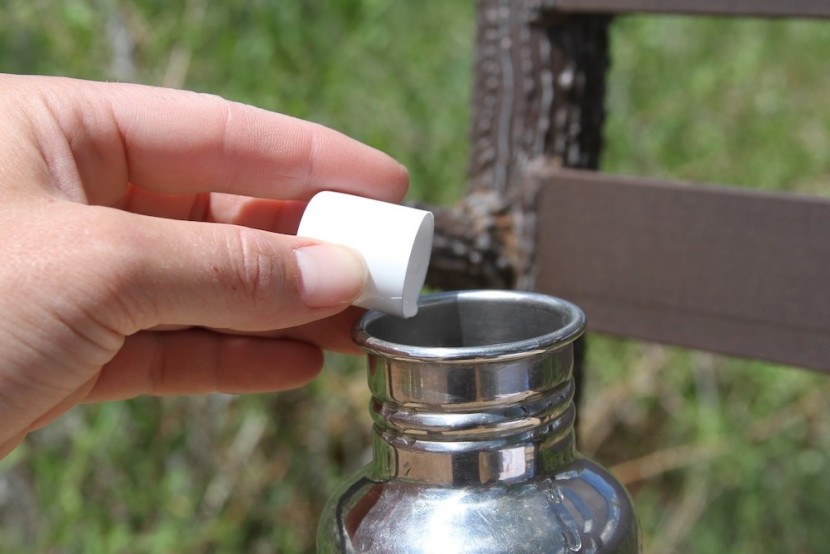 backpacking water filter - pouring the aquamira drops into our water to kill anything that we'd...