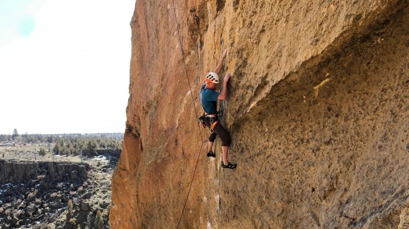 climbing a route on the welded tuff of smith rock while wearing the...