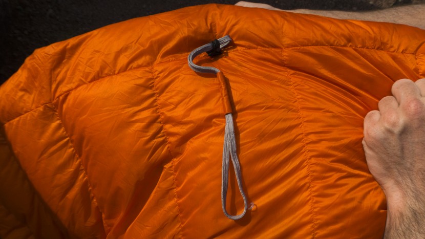 the rei trail magma 30 quilt utilizes a long cinch strap near the...