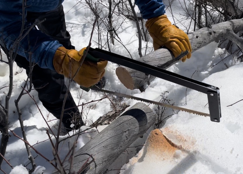 folding saw - the agawa effortlessly cuts a log in snowy wyoming.