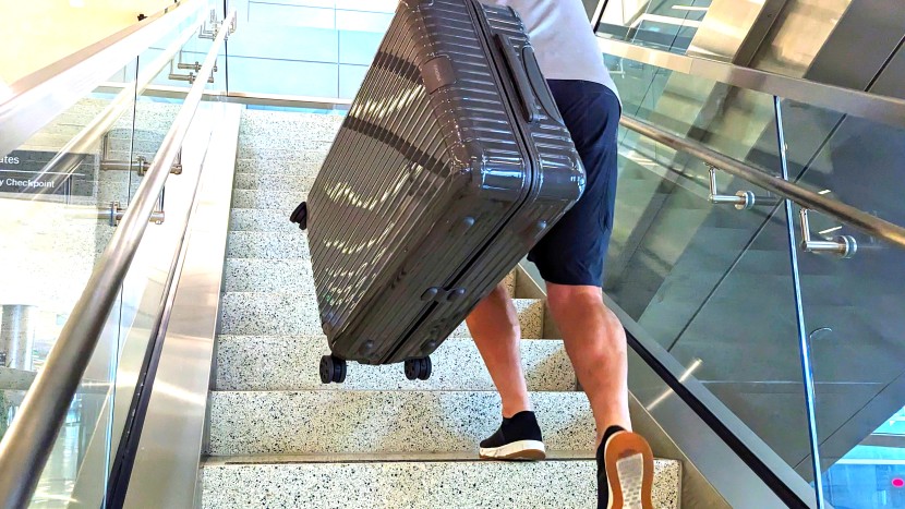 testing out the rimowa's grab handles on the airport's stair-stepper...
