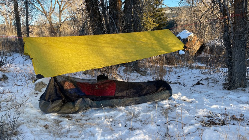 bivy sack - with a tarp strung between two trees and a cord suspending the mesh...