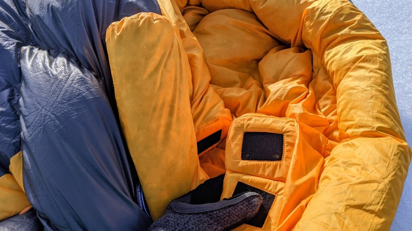 a hook-and-loop closure patch holds the neck baffle in place.